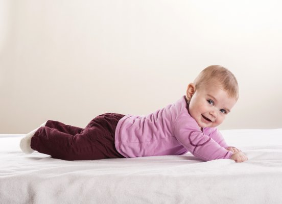 Baby on a mattress smilin